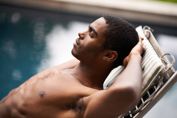 Take a moment to soak it up. A young man reclining in the summer sun. - Photo, Image