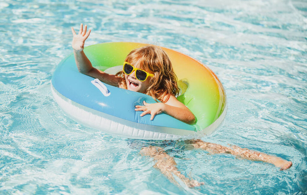 Nyári vakáció. Nyári gyerekek hétvégéje. Vicces fiú úszás medence felfújható gumi kör aquapark. - Fotó, kép