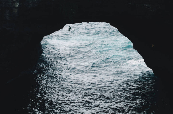 Вид из морской пещеры. вид на раскрашенную в лазурный цвет чистую воду и суровые скалы - Фото, изображение