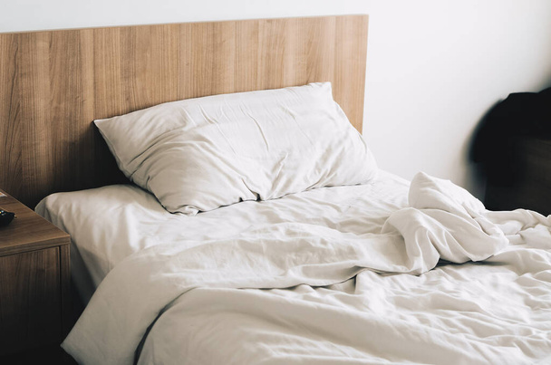 Chaotisches Bett mit Kissen in Nahaufnahme, weiße Bettwäsche. - Foto, Bild