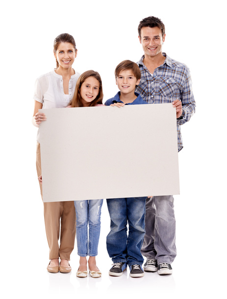 Tipo... Estúdio tiro de uma família feliz de pé com um cartaz em branco para copyspace. - Foto, Imagem
