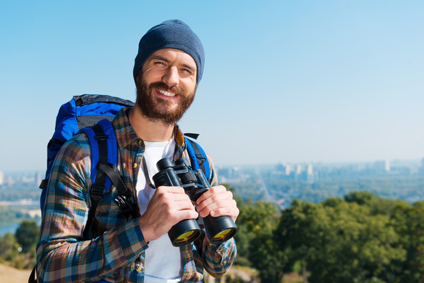 Man carrying backpack and holding binoculars - Foto, imagen