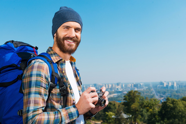 Man carrying backpack and holding camera - Foto, Imagen