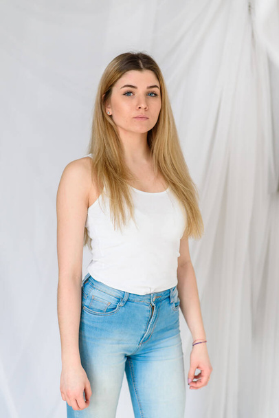 Pretty girl in a white t-shirt and blue jeans. - Valokuva, kuva