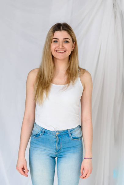Beautiful girl in jeans and a white t-shirt. - Zdjęcie, obraz