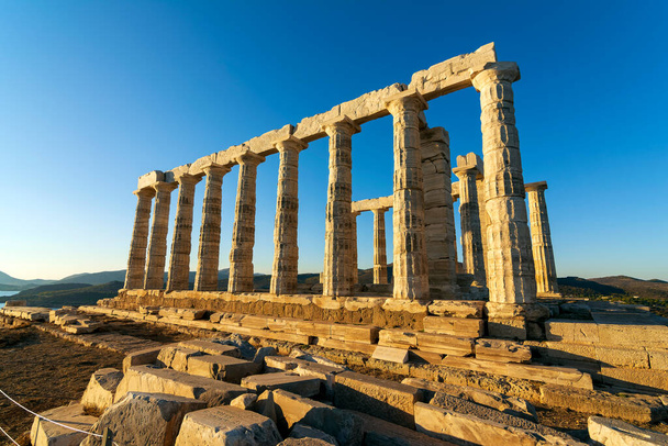 Ruins of an ancient temple of Poseidon at Greece Cape Sounio. Poseidon is the Greek god of the sea. Shot of temple ruins on sunset. Tourist landmark of Attica, Sounion, Greece. - Valokuva, kuva