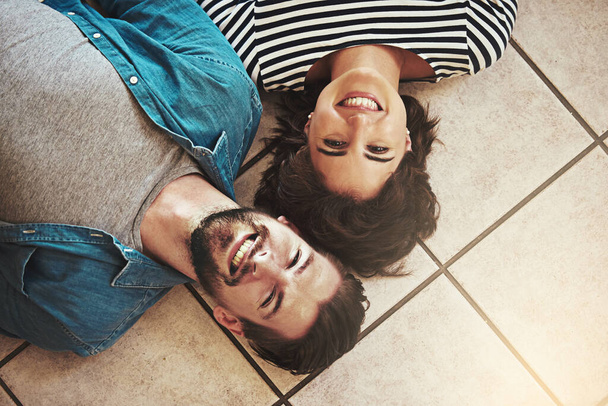 Were going to make our new home a happy one. Shot of a happy young couple relaxing on the floor of their new home. - Photo, Image