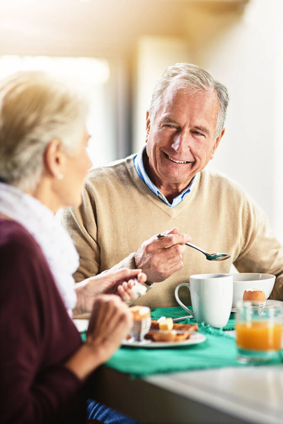 Tout bonheur dépend d'un petit déjeuner tranquille. Tourné d'un heureux couple de personnes âgées profitant du petit déjeuner ensemble à la maison. - Photo, image