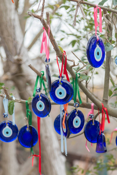 die Zweige des alten Baumes, geschmückt mit den augenförmigen Amuletten - Nazis aus blauem Glas, die im Goreme-Nationalpark, Kappadokien, der Türkei vor dem bösen Auge schützen sollten. - Foto, Bild