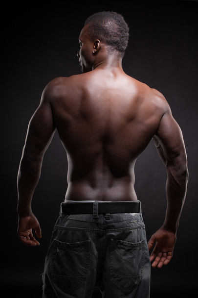Beautiful and muscular black man in dark background - Foto, Imagem