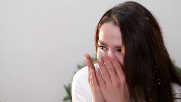 The brunette girl closes her eyes with her hands, she laughs happily - Footage, Video