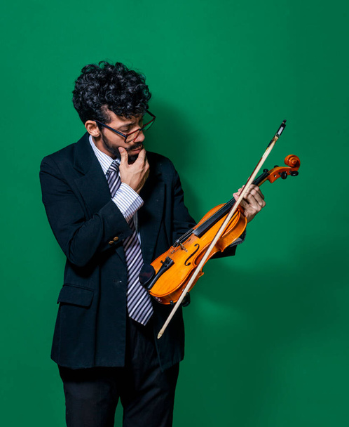 Feliz violinista con su violín, violinista mostrando su violín sobre un fondo aislado - Foto, Imagen