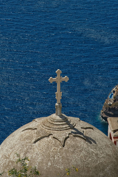 Αεροφωτογραφία της κορυφής ενός παλιού παρεκκλησίου με ένα σταυρό και την αιγαία θάλασσα στη Σαντορίνη - Φωτογραφία, εικόνα