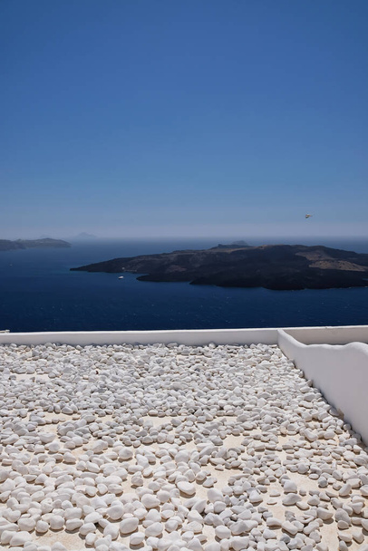 Kilátás a vulkán Santorini egy tető tele kövekkel - Fotó, kép