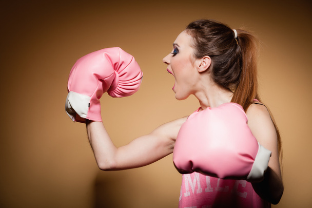 Female boxer wearing big gloves - Foto, Bild