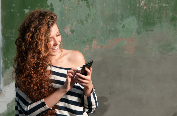 Fiatal, mosolygós nő használ smartphone - Fotó, kép