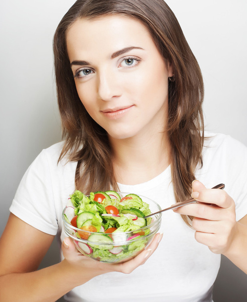 lachende meisje met een salade - Foto, afbeelding