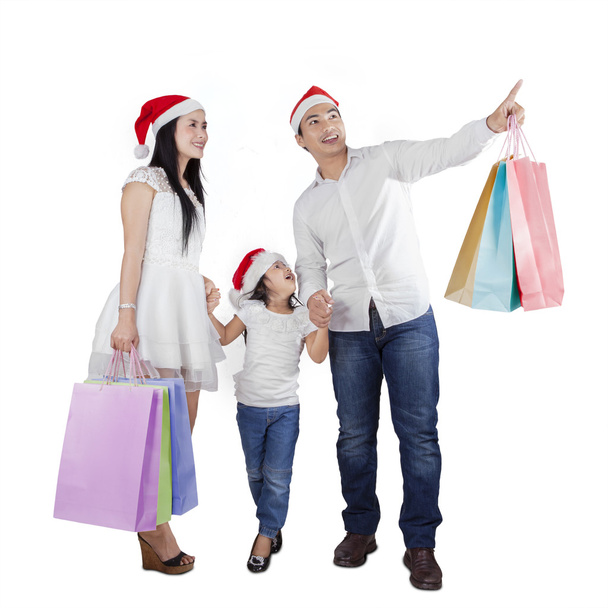 Family with santa hat and shopping bags - Фото, изображение