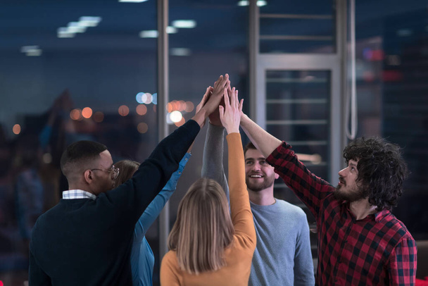 Overjoyed young multiethnic businesspeople have fun celebrate shared business success or victory in office. Smiling multiracial diverse employees feel excited win get good results. Teamwork concept. - Fotó, kép