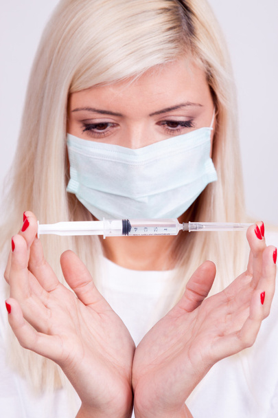 Femme médecin ou infirmière en masque médical tenant la seringue avec inje
 - Photo, image