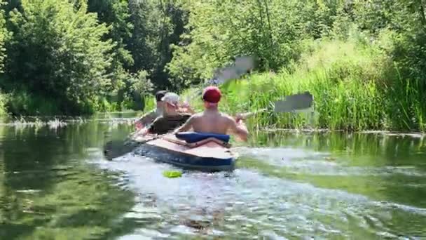 Een groep van drie mensen peddelen in een kajak. Raften op de snelle rivier. Avontuur reizen levensstijl. Concept zwerflust. Actieve weekendvakanties wilde natuur buiten. Het kanoën. - Video