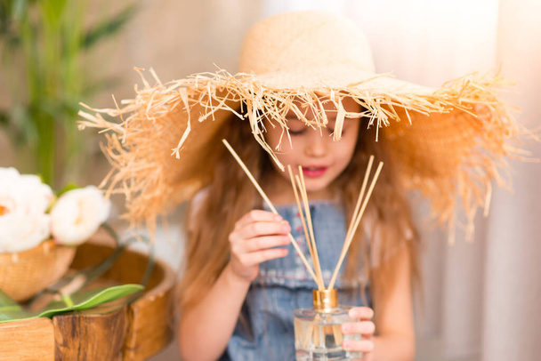 Little cheerful girl in a straw hat  - Fotó, kép