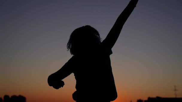 Triumph or winning: girl silhouette rising hand up and dancing - Footage, Video