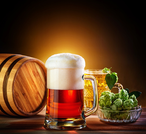 木製のテーブルのビールのグラスをビール樽。暗いれたら - 写真・画像