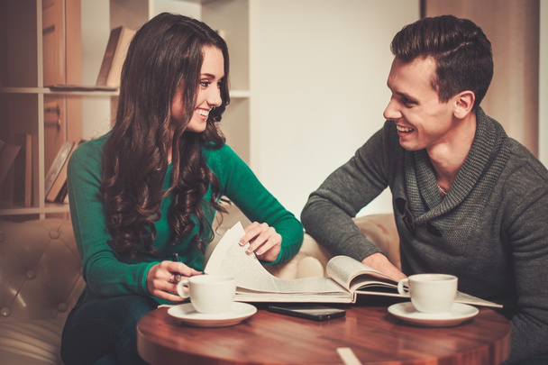 Couple avec café et livre discuter de quelque chose dans le café
  - Photo, image