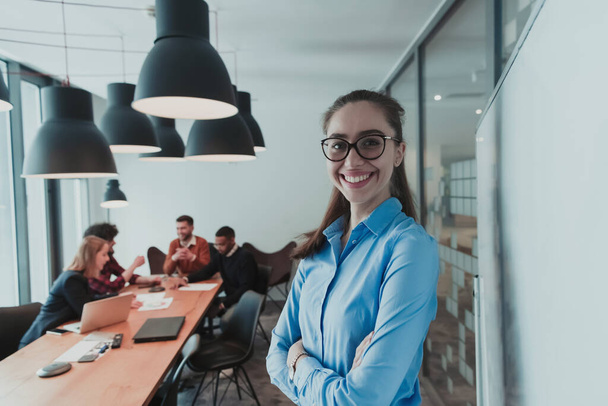 Portrait of happy businesswoman owner in modern office. Businesswoman smiling and looking at camera. Busy diverse team working in background. Leadership concept. Head shot. - Fotografie, Obrázek