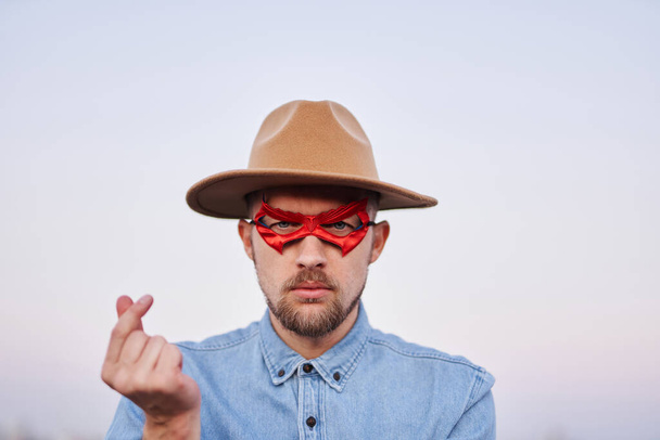 Людина в супергеройській червоній масці і капелюсі з корі міні серце - Фото, зображення