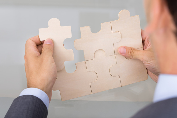 Businessman assembling jigsaw puzzle - Photo, Image