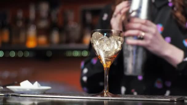 ruda dziewczyna młody dorosły kobieta barman przygotowuje mieszanki papier samolot koktajl bar wylewa lód dzwony - Materiał filmowy, wideo