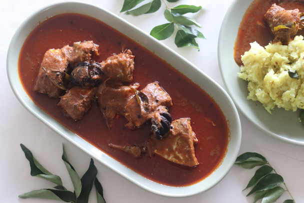 Curry de caballa preparado al estilo Kerala central con chiles rojos y tamarindo malabar. Servido con puré de casava seca o tapioca seca con coco rallado, chalotes, chiles, cúrcuma y hojas de curry - Foto, imagen