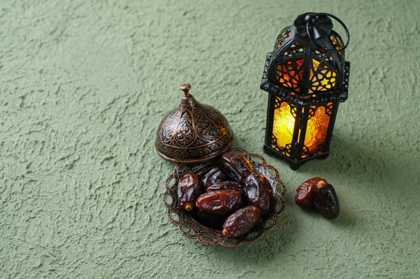Una lampada decorativa marocchina illuminata e date in un vecchio, piatto antico. Concetto di fondo del Ramadan - Foto, immagini