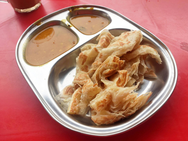 Traditional Malaysian signature flatbread food is called roti canai.  This is the type of pancake made from a mix of flour, egg and water. Eat with special sauce. - Photo, Image