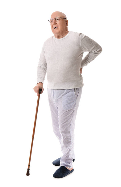 Senior man with walking stick suffering from back pain on white background - Foto, immagini