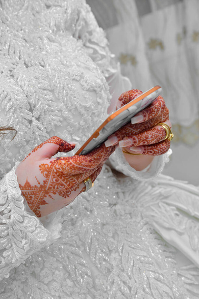Arabska panna młoda trzyma telefon w noc poślubną - Zdjęcie, obraz