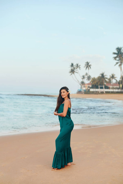 Portrait of beautiful young woman in dress on the beach. Pretty girl on tropical beach. Freedom concept, holiday, beach, sky background.  - Foto, immagini