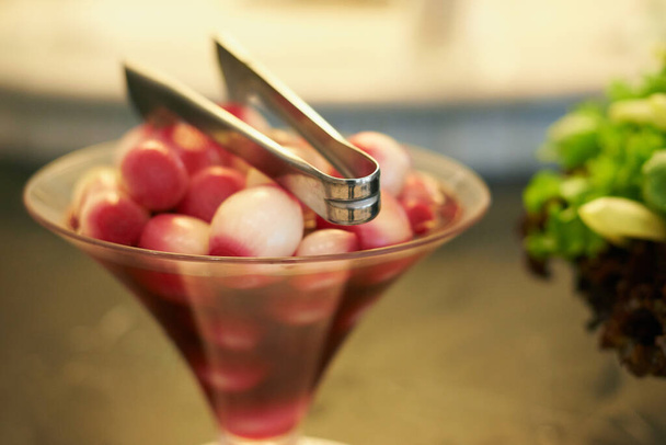 Ajouter une olive.... Olives disposées dans un verre avec pinces. - Photo, image
