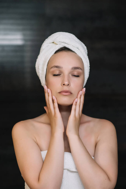 Bellezza donna asciugatura capelli con asciugamano sulla testa dopo il trattamento doccia. Giovane ragazza toccando la pelle morbida nel bagno - Foto, immagini