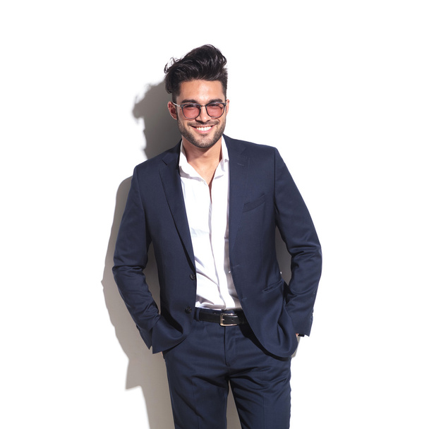 Smiling business man leaning on a white wall  - Photo, Image