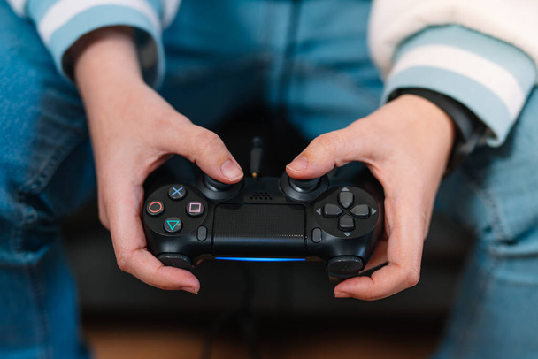 Dettaglio girato di una giovane donna mani con un controller di console video che gioca a un gioco. - Foto, immagini