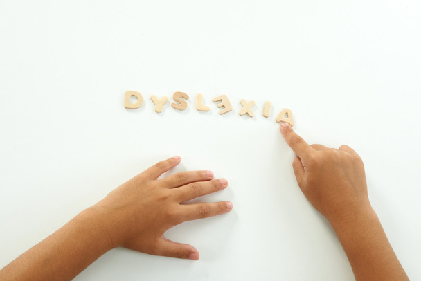 ręce dziewczyny tworzą słowo Dysleksja z litery drewniane - Zdjęcie, obraz