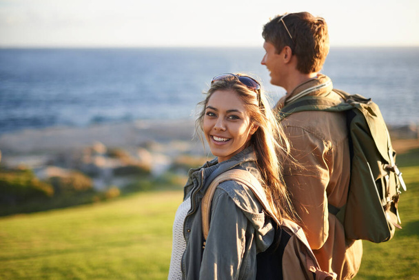 We go everywhere together. Portrait of a young couple standing on the edge of an embankment overlooking the ocean. - Foto, imagen