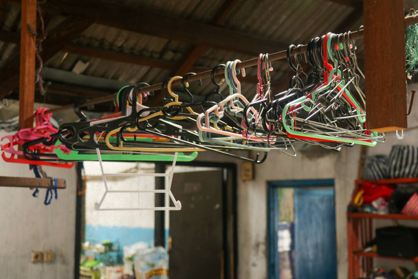Mnoho několik kovových drátěné závěsy na tyč pro zavěšení oblečení ve skříni skladu. - Fotografie, Obrázek