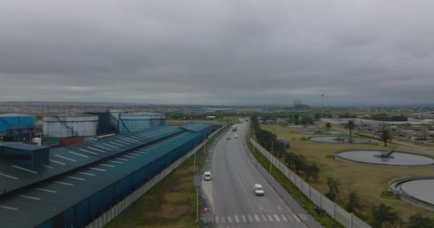 Vpřed přeletět nad silniční nakládkou na průmyslovém předměstí v zamračený den. Velké válcové nádrže na materiál v továrně. Port Elisabeth, Jihoafrická republika - Záběry, video