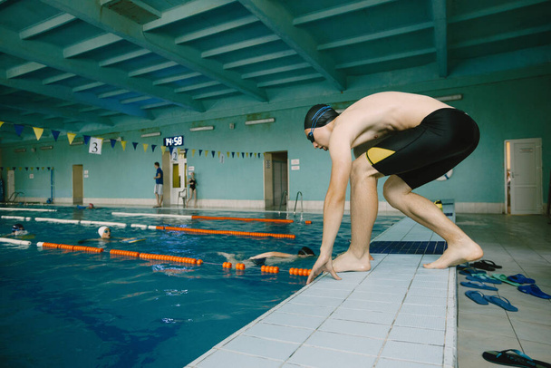 Male swimmer jumping in a swimming pool - Zdjęcie, obraz