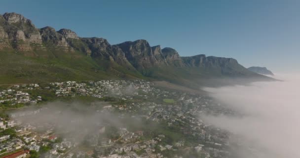 Sestupný záběr skalního srázu nad turistickou destinací. Z moře stoupá mlha. Kapské Město, Jihoafrická republika - Záběry, video