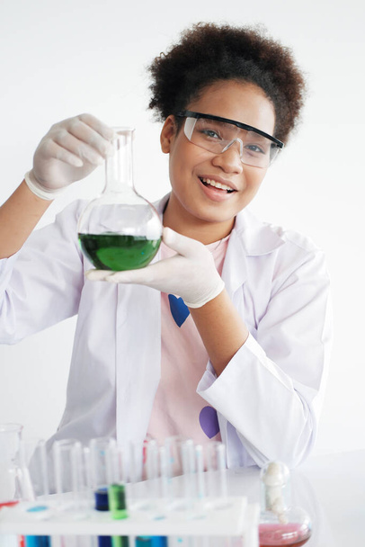 Usmívající se africká černoška studentka je studium a test chemie a vědy. Experimentuje v laboratoři ve škole. Koncepce vzdělávání a znalostí. - Fotografie, Obrázek